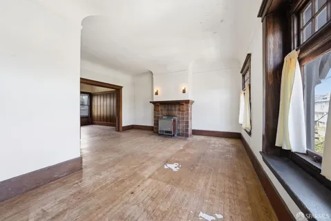 a view of a room with wooden floor staircase and a kitchen