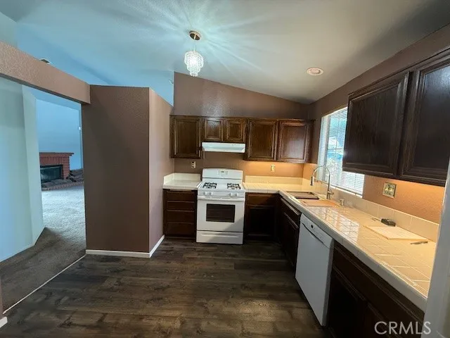 a kitchen with stainless steel appliances kitchen island granite countertop a refrigerator stove and sink