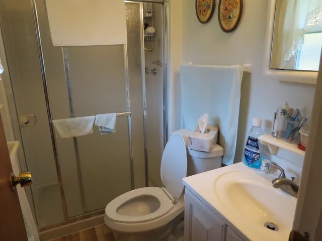 a white toilet sitting next to a bathroom sink and a shower
