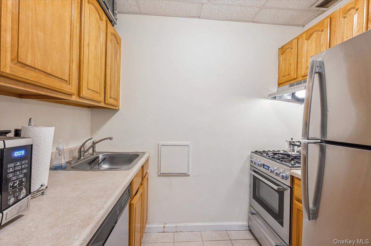 1250 North Avenue, Unit 115 New Rochelle, NY 10804 - Photo 6 of 16 a kitchen with a refrigerator sink and stove