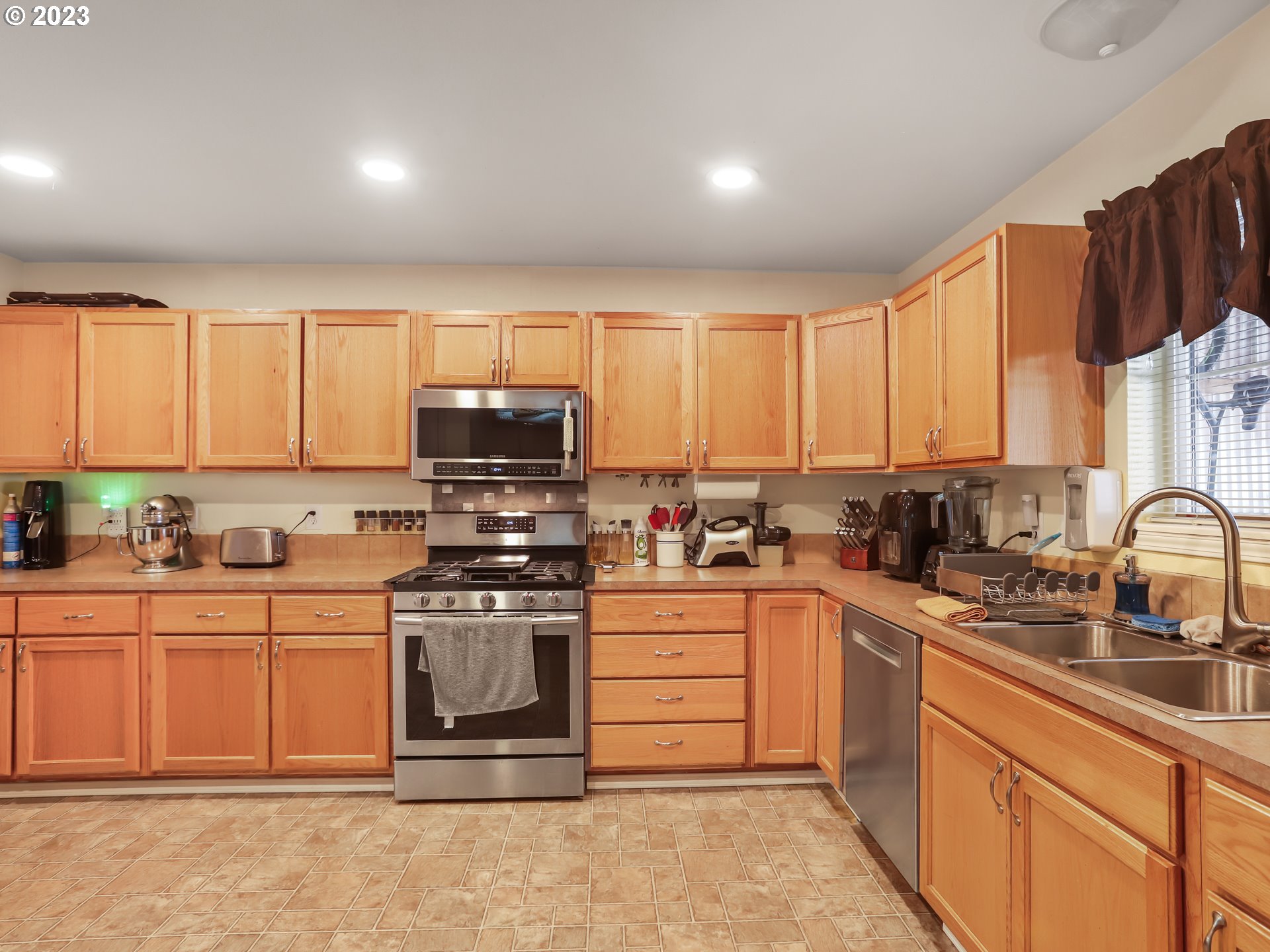 18533 Southwest Deloris Lane Beaverton, OR 97007 - Photo 11 of 43 a kitchen with stainless steel appliances granite countertop a stove sink and cabinets