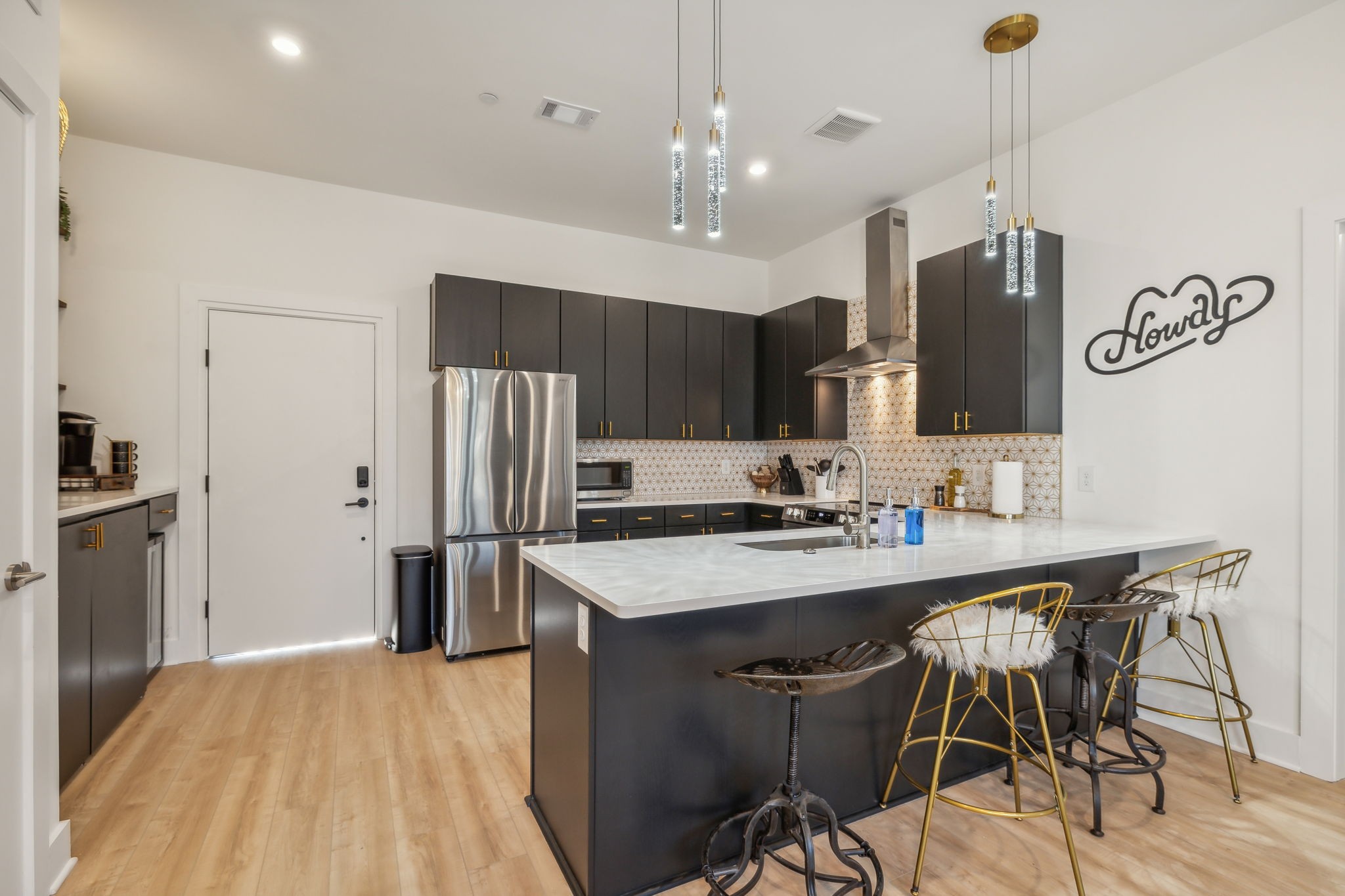 a kitchen with kitchen island a sink stove and refrigerator with wooden floor