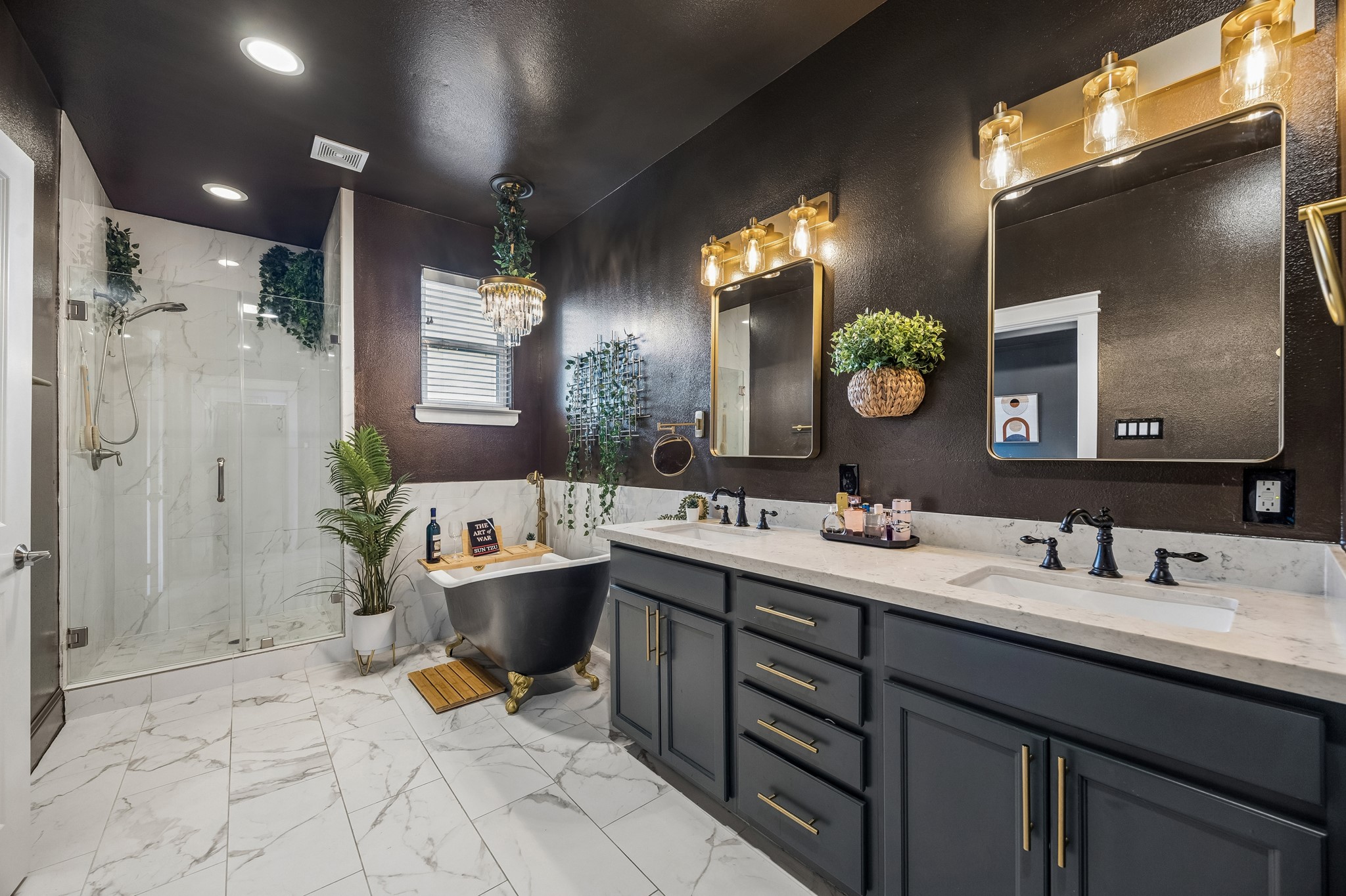 624 East 28th Street Houston, TX 77008 - Photo 22 of 34 The primary bath features dual vanities, updated mirrors and lighting, a cast-iron soaking tub, and a separate glass-enclosed shower.