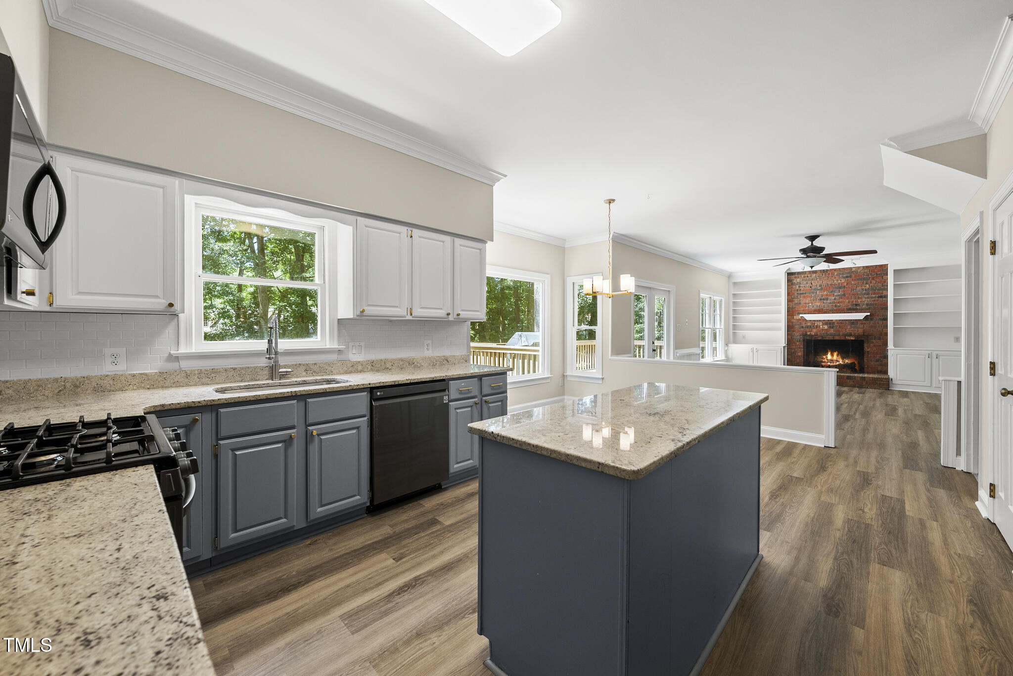 8716 Mourning Dove Road Raleigh, NC 27615 - Photo 11 of 44 a kitchen with granite countertop kitchen island stainless steel appliances a sink stove and cabinets