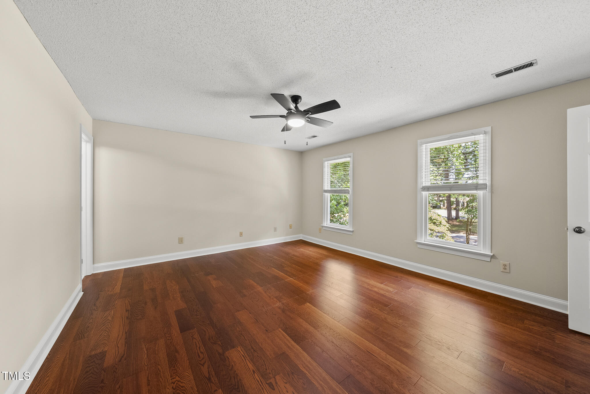8716 Mourning Dove Road Raleigh, NC 27615 - Photo 12 of 44 an empty room with wooden floor and windows