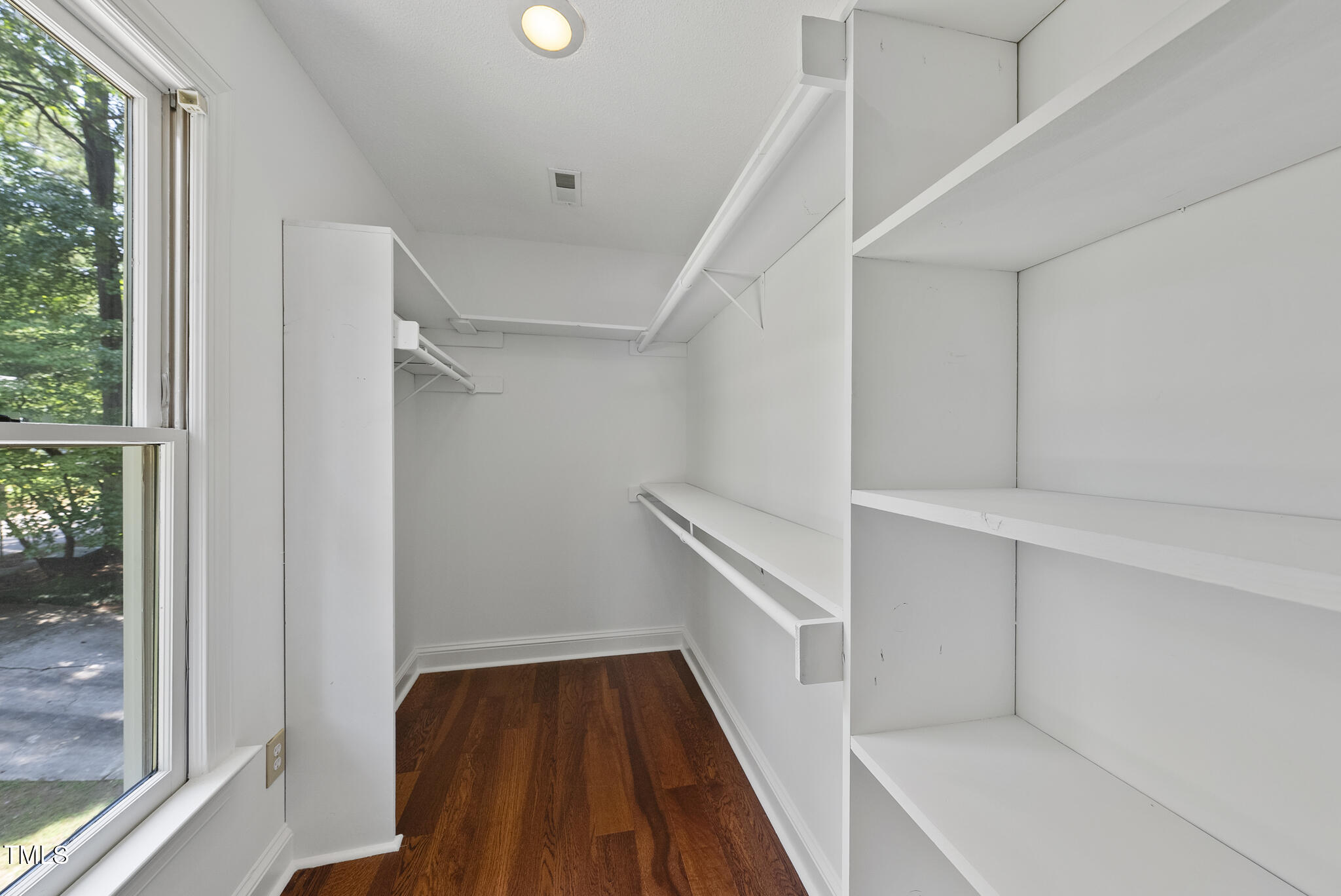 8716 Mourning Dove Road Raleigh, NC 27615 - Photo 13 of 44 a view of walk in closet with wooden floor and entryway