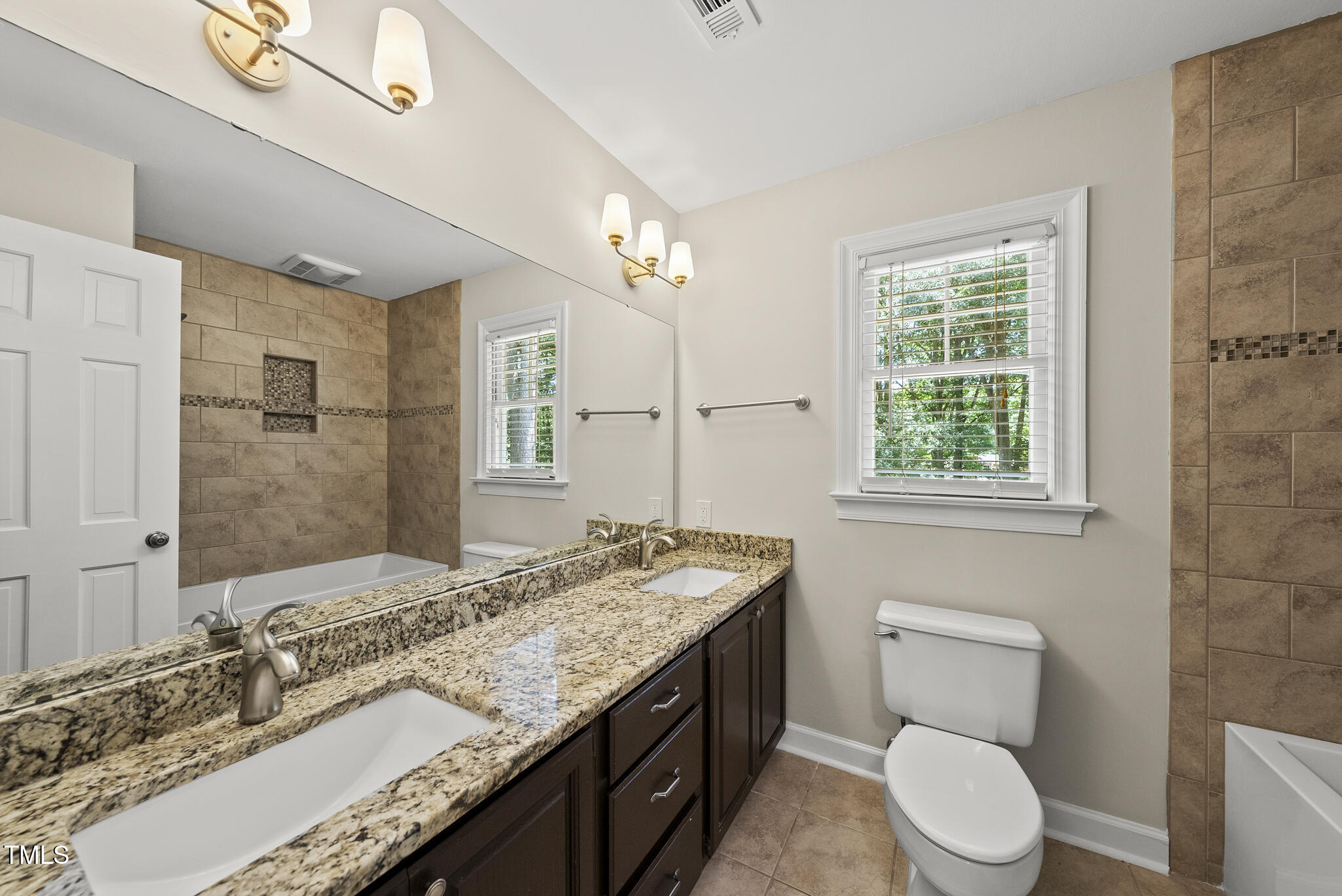 8716 Mourning Dove Road Raleigh, NC 27615 - Photo 17 of 44 a bathroom with a granite countertop double vanity sink toilet and a mirror