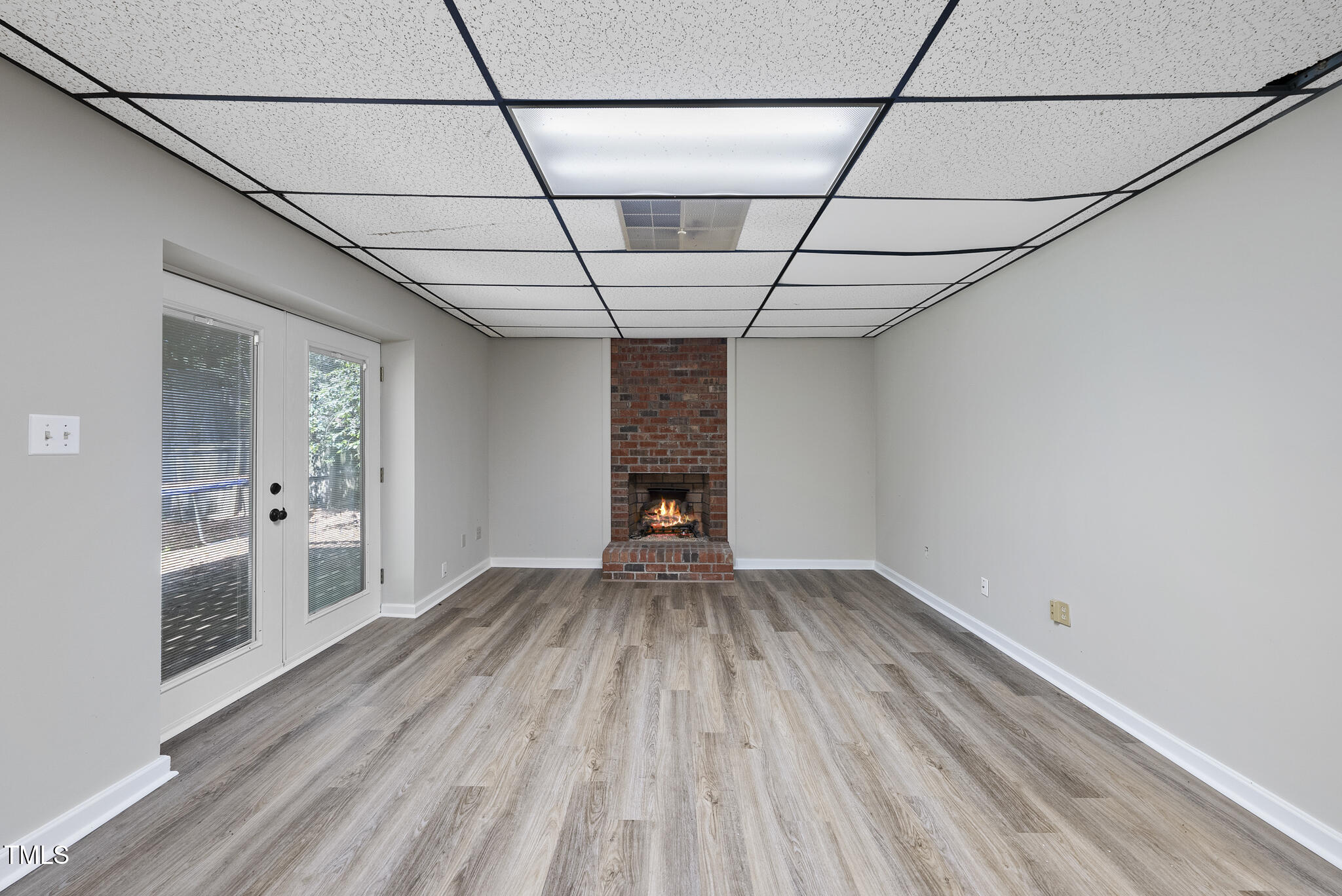 8716 Mourning Dove Road Raleigh, NC 27615 - Photo 29 of 44 a view of empty room with wooden floor and fireplace