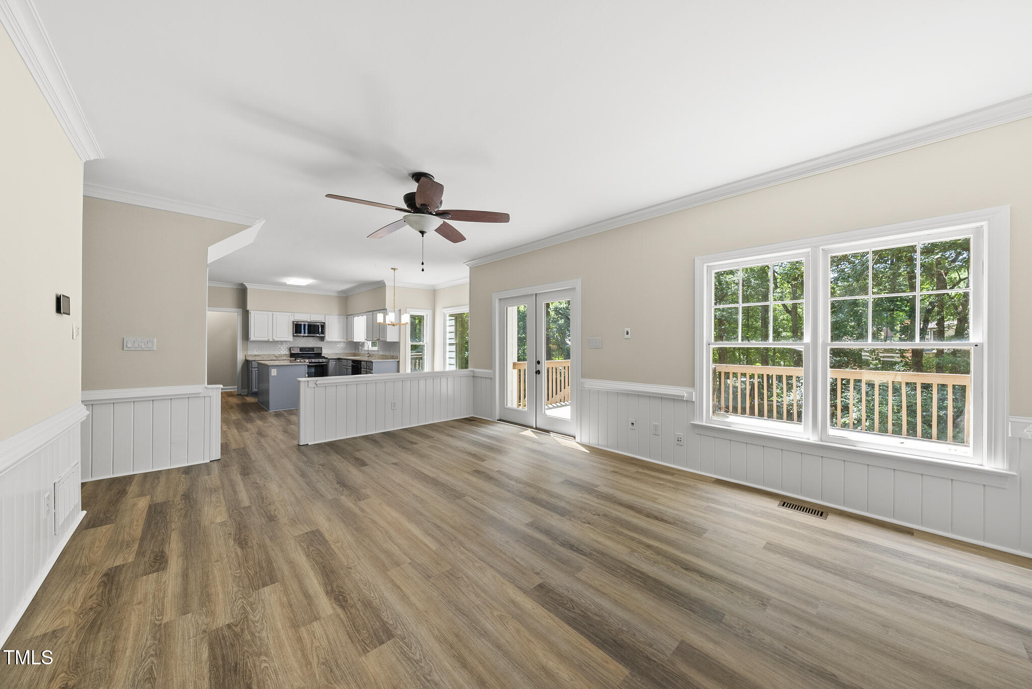 8716 Mourning Dove Road Raleigh, NC 27615 - Photo 6 of 44 a view of an empty room with wooden floor and a kitchen