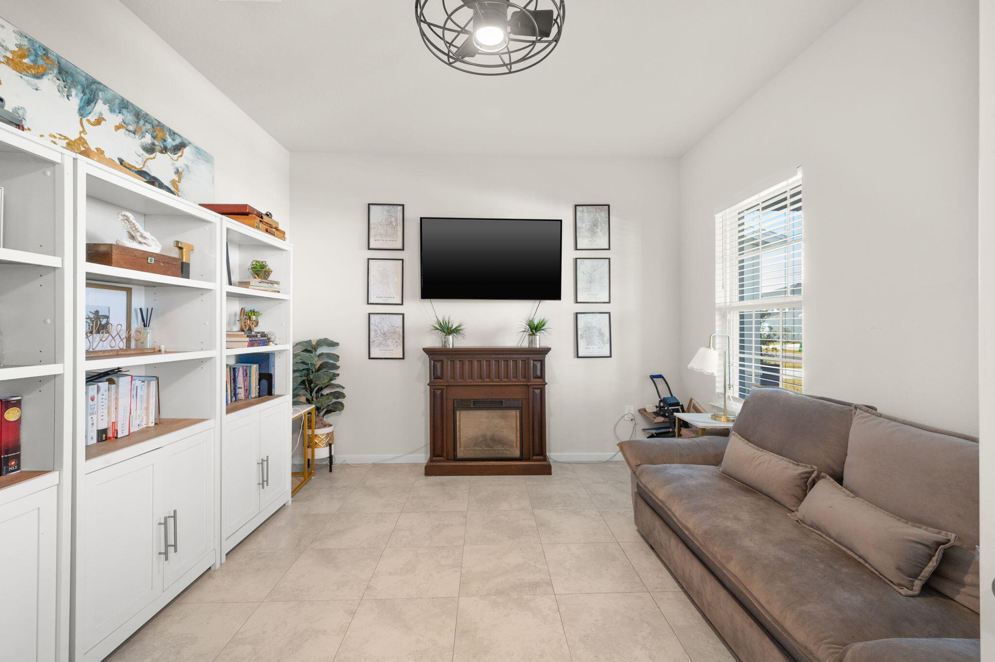 12297 Southwest Forli Way Port Port St. Lucie, FL 34987 - Photo 5 of 37 a living room with furniture a flat screen tv and a fireplace