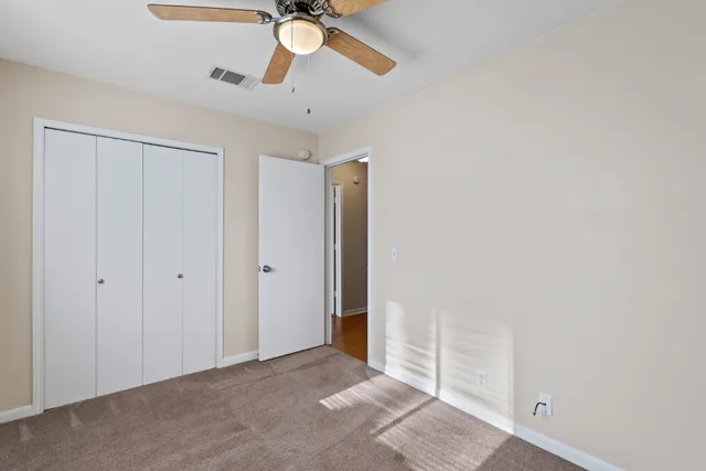 an empty room with a ceiling fan and a window