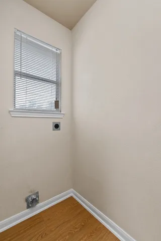 a view of a small space with wooden floor and a window