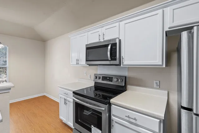 a kitchen with stainless steel appliances a stove a microwave oven cabinets and a counter top space