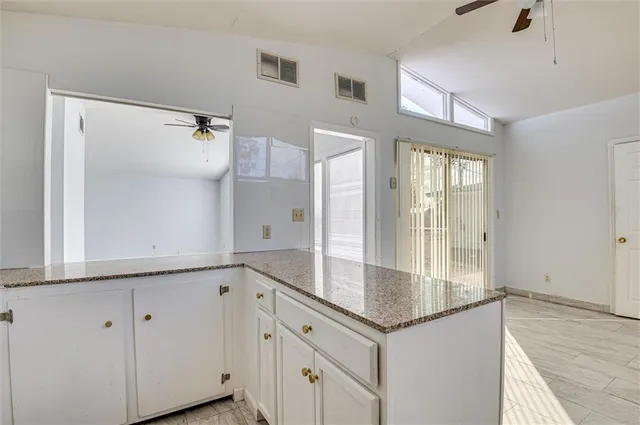 a view white cabinets with granite countertop a sink and dishwasher with wooden floor