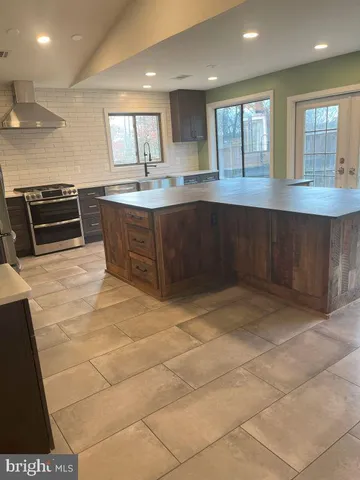 a kitchen with stainless steel appliances a sink a stove a microwave and cabinets
