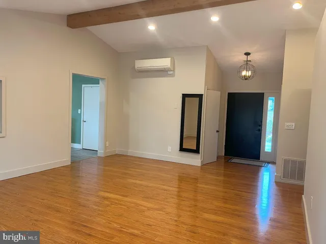 a view of an empty room with wooden floor