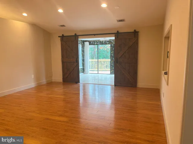 a view of empty room with wooden floor