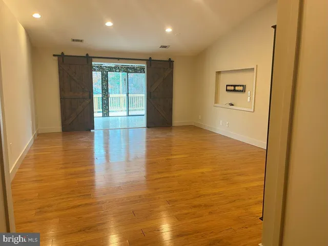 a view of a hallway with wooden floor and windows