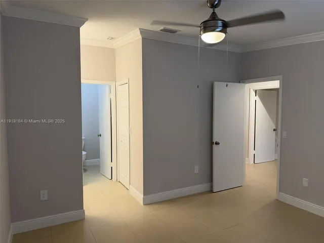 an empty room with closet and a hallway