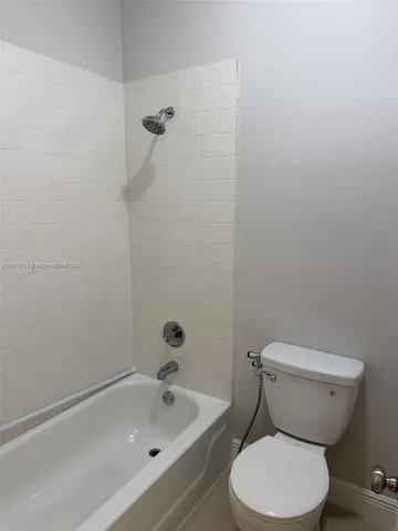 a white toilet sitting next to a bath tub
