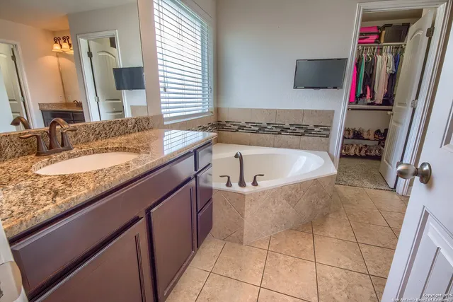 a bathroom with a granite countertop bathtub and a sink