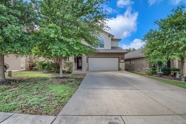a front view of a house with a yard and a garage