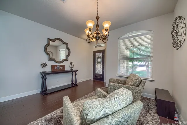 a living room with furniture chandelier and a window