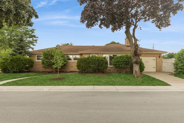 a view of a house with a big yard and large trees