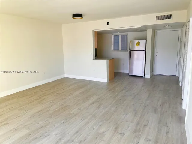 a view of a kitchen with wooden floor and stainless steel appliances