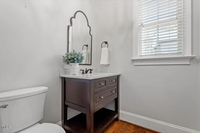a bathroom with a sink vanity mirror and toilet