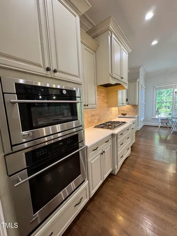 a kitchen with stainless steel appliances and white cabinets