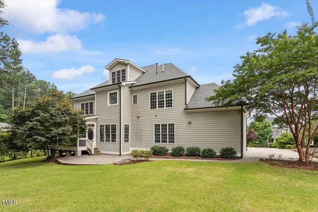 a front view of a house with a garden and tree