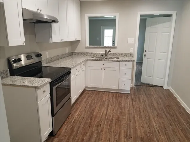 a kitchen with a sink stove and cabinets