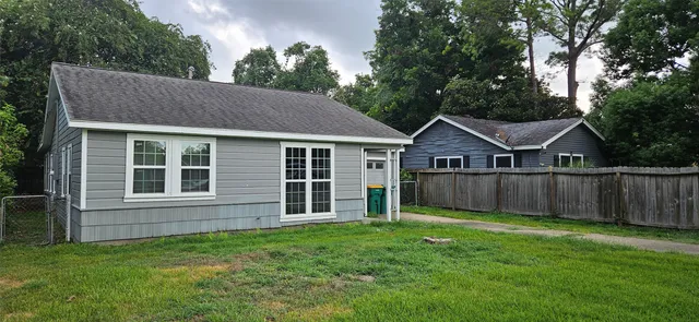 a view of a yard in front of a house with wooden fence
