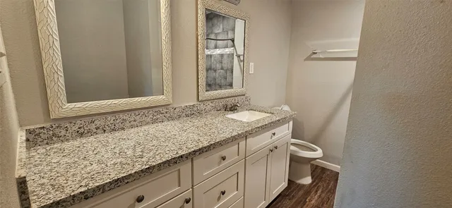 a bathroom with a granite countertop sink and a mirror