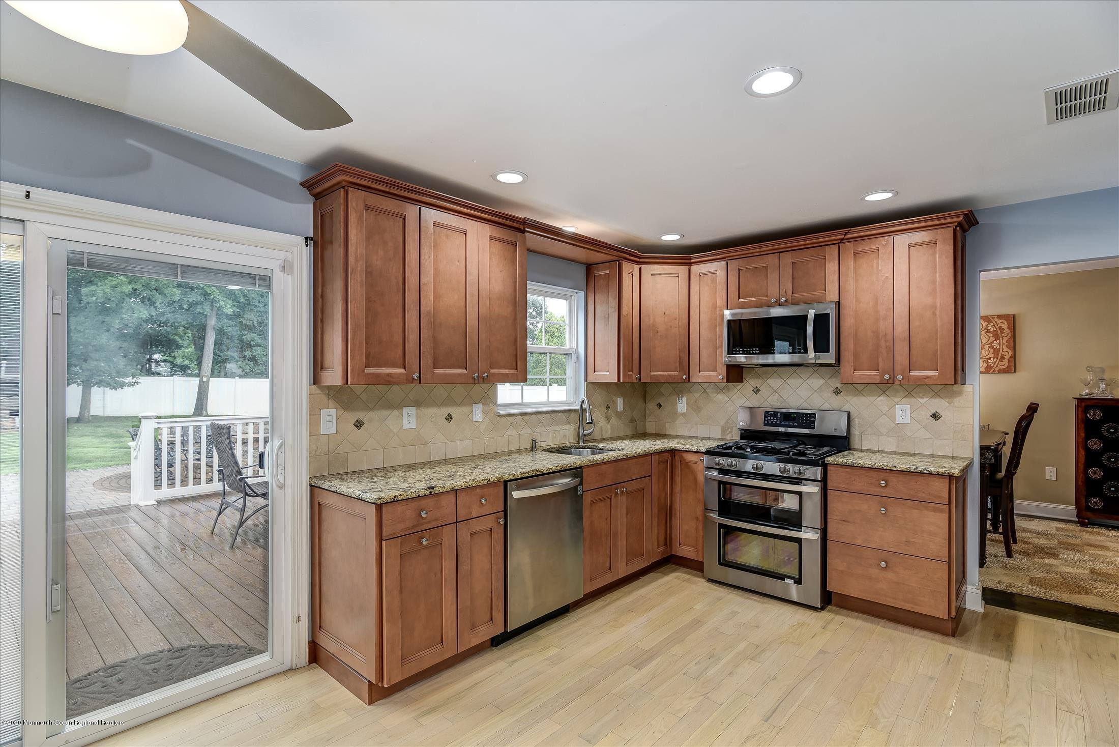 11 Sun Hollow Road Howell, NJ 07731 - Photo 7 of 27 a kitchen with stainless steel appliances granite countertop wooden cabinets a sink a stove a refrigerator and dishwasher with wooden floor