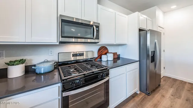 a kitchen with stainless steel appliances granite countertop a stove a microwave and a refrigerator