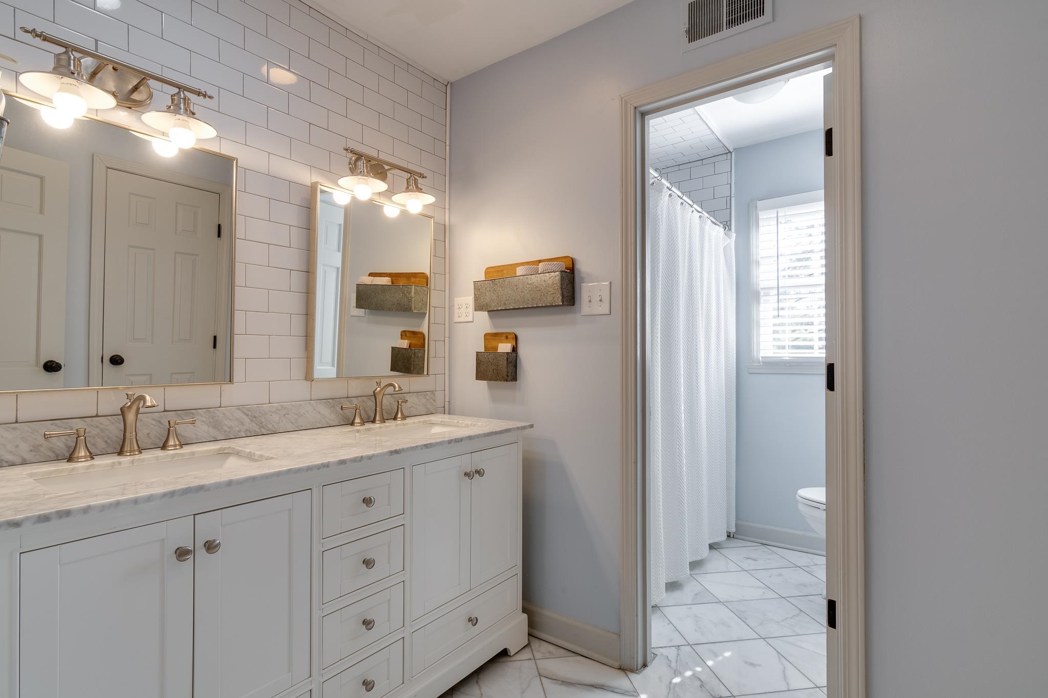 6417 Wood Bridge Road Memphis, TN 38119 - Photo 20 of 25 This renovated bath has marble countertops with two sinks and marble floors; the shower/bath tub combo has white subway tile. The fixtures are even lovely upstairs!