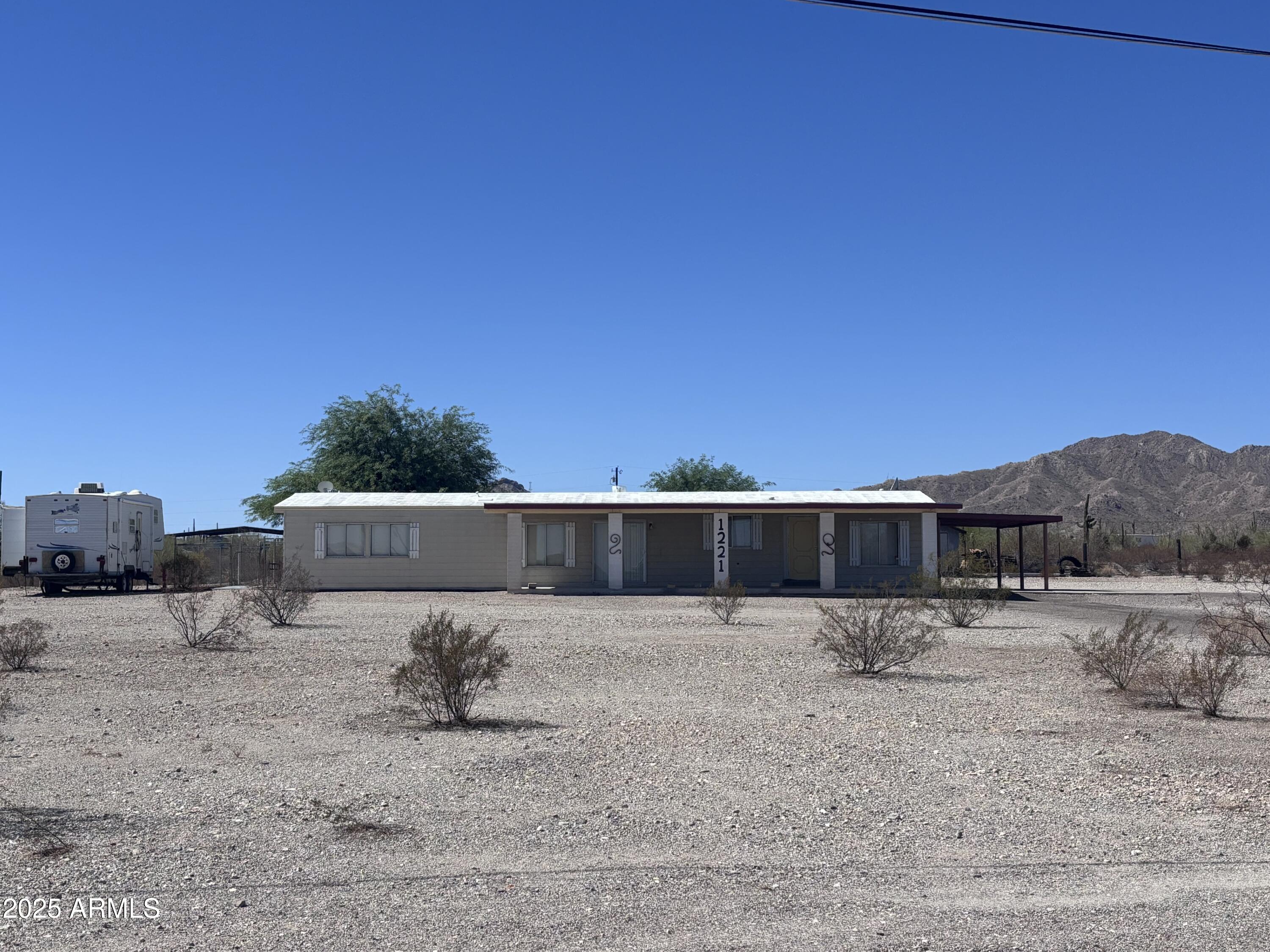 a view of a dry yard with large trees