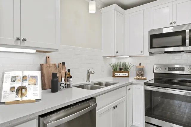 a kitchen with stainless steel appliances a stove microwave and sink