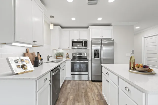 a kitchen with white cabinets and stainless steel appliances