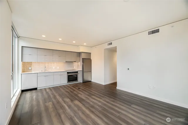 a large kitchen with a wooden floor and stainless steel appliances