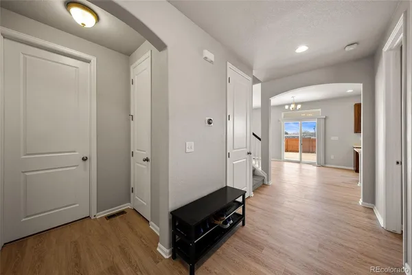 a view of a hallway with wooden floor and furniture