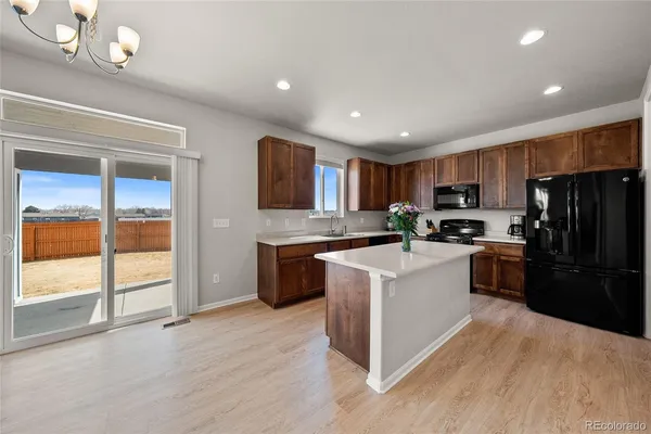 a kitchen with granite countertop a refrigerator stove top oven and sink