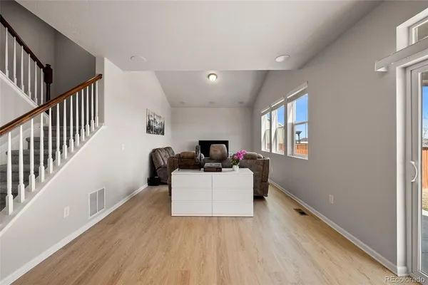 a living room with furniture and a wooden floor