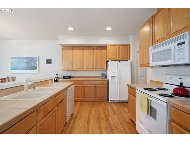 a kitchen with a sink a refrigerator a stove top oven a counter space and cabinets