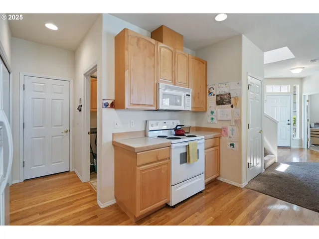 a kitchen with stainless steel appliances a stove a refrigerator a sink and cabinets
