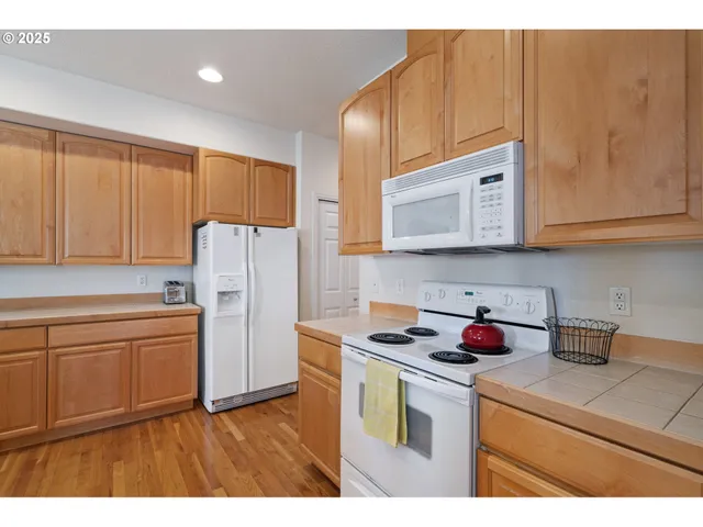 a kitchen with stainless steel appliances granite countertop a refrigerator sink and microwave