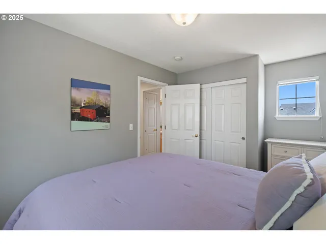 a bedroom with a bed and a painting on the wall
