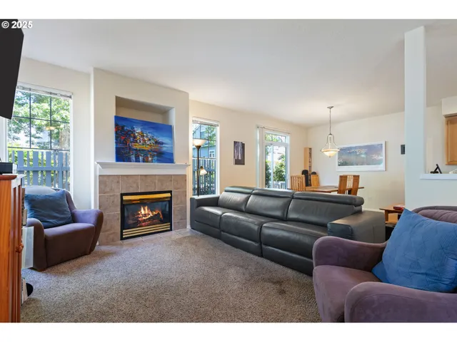 a living room with furniture a flat screen tv and a fireplace
